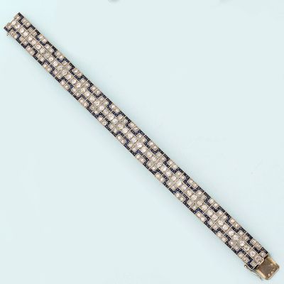 a close up of a black and white bracelet on a white surface