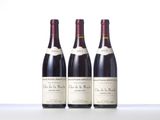 three bottles of wine are lined up on a table