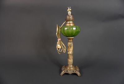 une image représentant une lampe verte posée sur un socle en bois, avec un cordon