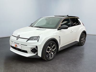 La voiture blanche est garée dans une grande pièce au sol noir.