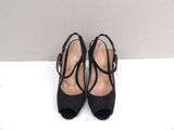 pair of black high heeled shoes on a white surface