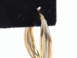 a close up of a pair of gold hoop earrings on a black velvet holder