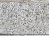 an old stone plaque with writing on it in front of a building