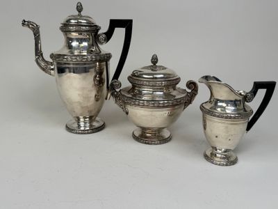 three pieces of silver tea and coffee set on a white surface