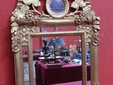 un miroir posé sur une table devant un mur rose