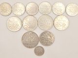 plusieurs types de pièces de monnaie sont disposés sur une surface blanche