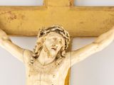a statue of jesus on a wooden cross on the wall