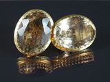 une paire de boucles d'oreilles en quartz topaze jaune sur un fond noir