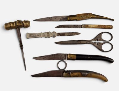 cinq types de ciseaux différents et un couteau sur la table