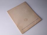 un vieux livre posé sur une table sur une surface blanche