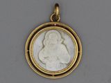 a close up of a gold pendant with a picture of a woman