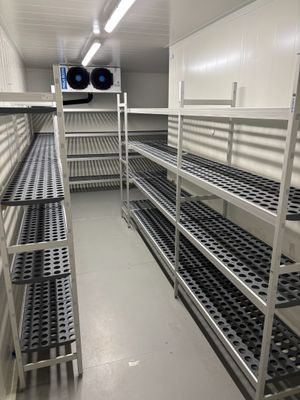 de nombreuses étagères au milieu d'une pièce, sur lesquelles sont disposés de nombreux objets