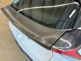 a close up of a car ' s rear window with a reflection of a building in the window