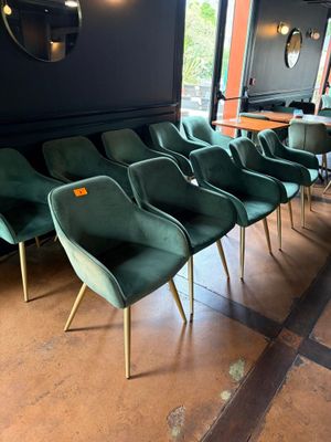 Plusieurs chaises vertes sont alignées en rang dans un restaurant