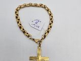 a gold chain bracelet with a cross and a tag on it