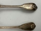 two spoons that are sitting next to each other on a table