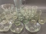 many glasses and a pitcher sitting on a table