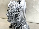 a ceramic sculpture of a man ' s head on a table