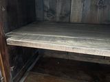 a wooden cabinet with a shelf on top of it
