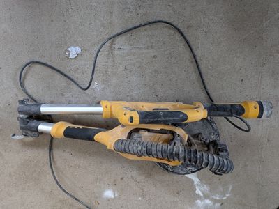 an image of a corded drill on a concrete floor