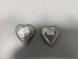 two silver hearts with a sticker on them sitting on top of a table