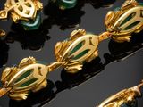 a close up of a gold and green necklace and bracelet