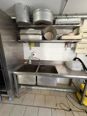 a kitchen with a stove, sink, and a refrigerator
