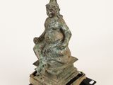 une image représentant une statue d'une femme assise sur une pile de livres
