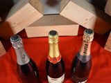 three bottles of wine sitting on a red cloth
