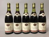 six bouteilles de vin sont alignées sur une table