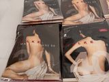 six dvds of a woman in a white dress sitting on a white surface