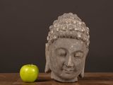 a statue of a head and an apple on a table