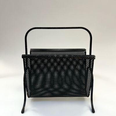 une image représentant un porte-revues en métal noir sur fond blanc