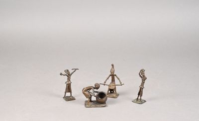 quatre figurines représentant des personnes assises sur une surface blanche