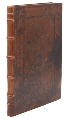 un vieux livre à la couverture brune posé sur une surface blanche