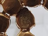 a close up of a gold bracelet with a cross on it
