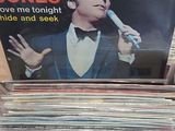 a person holding a stack of vinyl records on a table