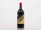 a bottle of red wine sitting on top of a white table