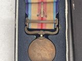 an old medal in a box with a ribbon on it