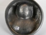 an old metal bowl sitting on top of a white surface