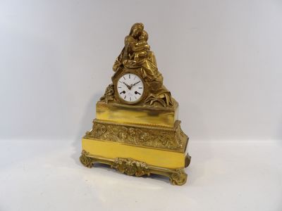 une horloge en or posée sur une table blanche