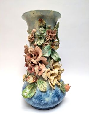 a blue vase with flowers on it on a white background