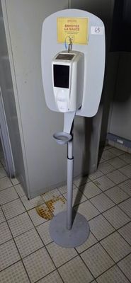 a toilet in a public restroom with a sign on it