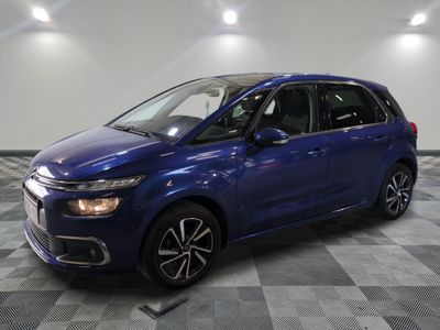 a blue citrole parked on a checkered floor in a garage