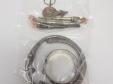 deux bracelets en argent et une paire de ciseaux dans un sac