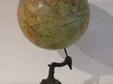 a statue of a man holding a large globe on a stand