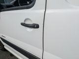 a white van with a black stripe parked in a parking lot