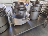 many pots and pans sitting on a shelf in the kitchen