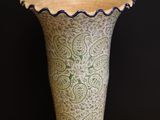 a vase that is sitting on a table in front of a black wall
