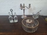 candlesticks and salt shakers on a wooden table with a white wall in the background